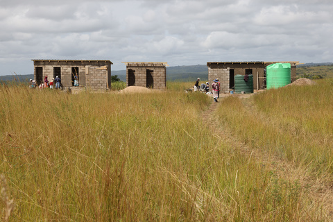 Local parents work with builders to construct new latrines at a rural school 